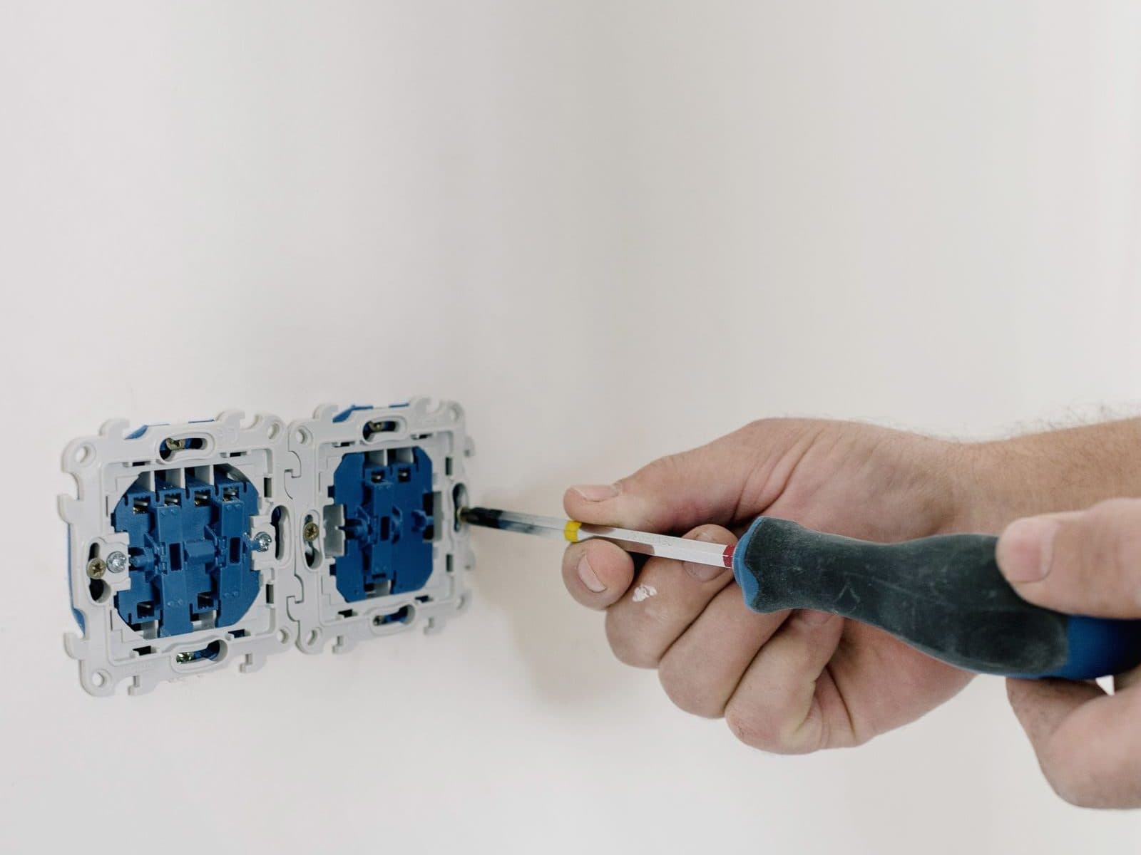 Pose de mécanismes de prises encastrés dans un mur repeint, lors d'une rénovation électrique