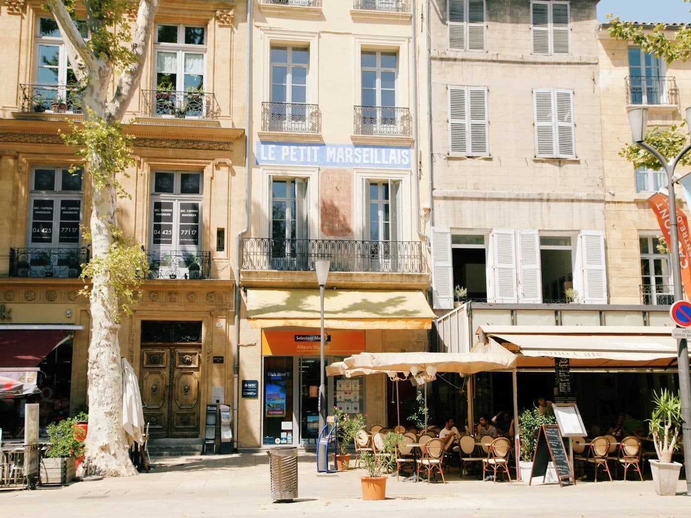 Rue commerçante d'Aix-en-Provence bordée de façades anciennes et de terrasses